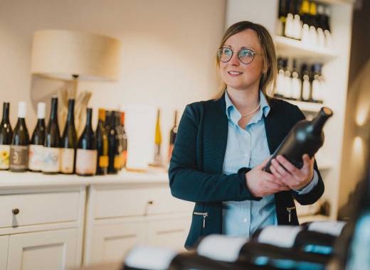 Frau Caroline Zuber mit Weinflasche im Weinhotel