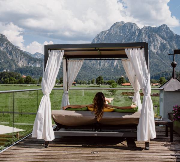 Frau in Dailybett auf dem Panoramadeck mit Blick aufs Schloss